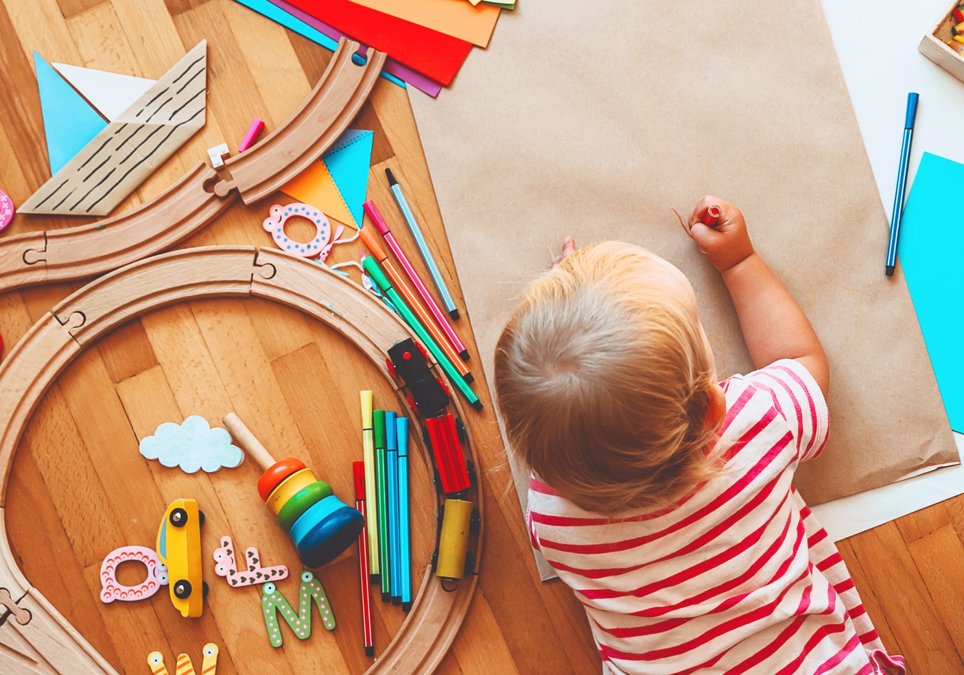 Bild på ett litet barn som leker och ritar på brunt paper